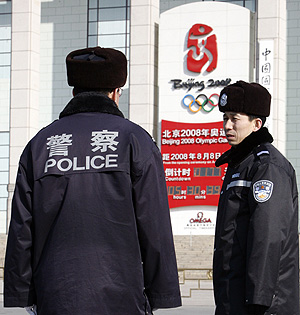 Dos policas vigilan la plaza de Tiananmen ante un cartel de los Juegos Olmpicos. (Foto: REUTERS)