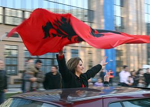 Una mujer ondea una bandera albanesa en Bruselas. (Foto: AFP)