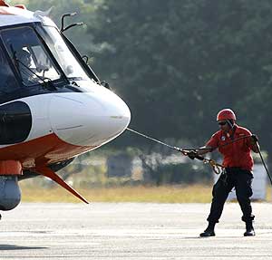 Un operario ayuda a aterrizar el helicóptero de rescate. (Foto: REUTERS)