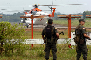 Policías colombianos observan los dos helicópteros venezolanos que han participado en la liberación de los secuestrados en el aeropuerto de San José del Guaviare, en el sur de Colombia. (Foto: EFE)
