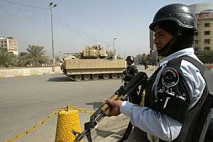 Dos policías iraquíes y un tanque en puesto de control de carretera. (Foto: AFP)
