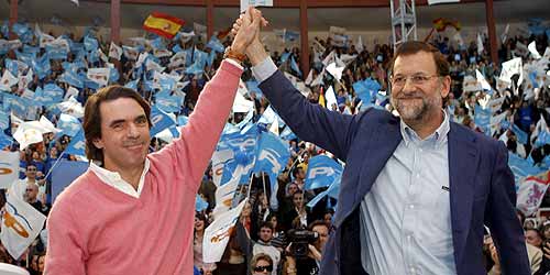 Aznar y Rajoy se dan la mano en el mitin de Len. (Foto: EFE)