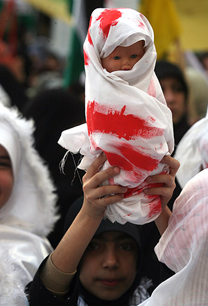 Un nio con una mueca pintada de rojo, que representa a los menores asesinados. (Foto: AP)