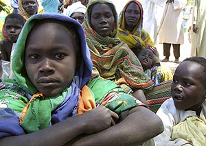 Familias de refugiados sudaneses esperan a la entrada de un campo de refugiados. (REUTERS)