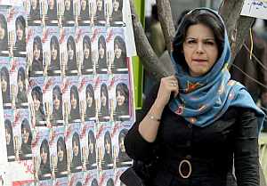Una mujer pasa por delante de carteles electorales de los candidatos conservadores en una calle de Tehern. (Foto: EFE)