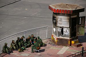 Soldados chinos, vigilando una zona quemada durante los disturbios de ayer. (Foto: AP)