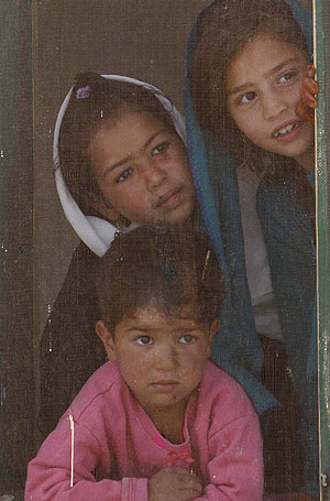 Tres nios afganos miran por la ventana de su colegio. (Foto: AP)