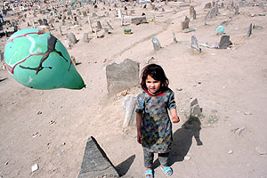 Una nia afgana juega con un globo en un cementerio de Kabul, Afganistn. (EFE)