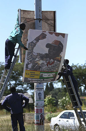 Trabajadores retiran los carteles de campaa de Mugabe. (Foto:AP)