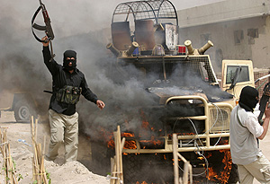 Varios guerrilleros celebran la quema de un vehculo. (Foto: AP | Nabil Al Jurani)