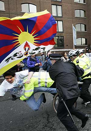 La polica londinense neutraliza a un activista al paso de la antorcha. (Foto: AP)