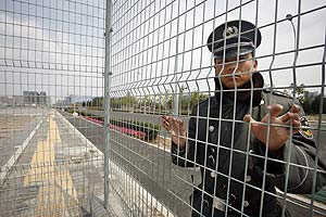 Un agente de seguridad chino vigila la valla del Estadio Nacional de Pekn. (Foto: REUTERS)