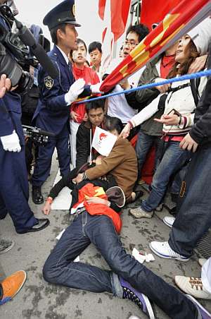 Un seguidor pro chino yace herido en el suelo tras los enfrentamientos con pro tibetanos. (Foto: AFP)