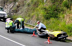 Miembros de la Guardia Civil se disponen al traslado de uno de los tres motoristas muertos el sbado en Asturias. (Foto: EFE)