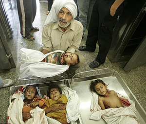 Un trabajador de un hospital muestra los cuerpos de los cuatro nios muertos por el ataque israel. (Foto: REUTERS)