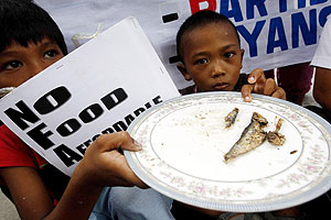Nios filipinos muestran un plato con una sardina durante una protesta por la crisis en Filipinas. (EFE)