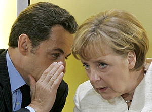 Sarkozy cuchichea con Merkel, durante la entrega del Premio Carlomagno en Aquisgrn (Alemania). (Foto: AP)