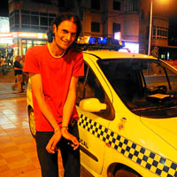 Cezar Camoroso, fotgrafo rumano en paro, bromea junto al coche de Polica. (Foto: Alberto Vera)