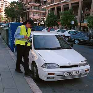 Una polica pone una multa a un coche mal aparcado. (Foto: Pep Vicens)