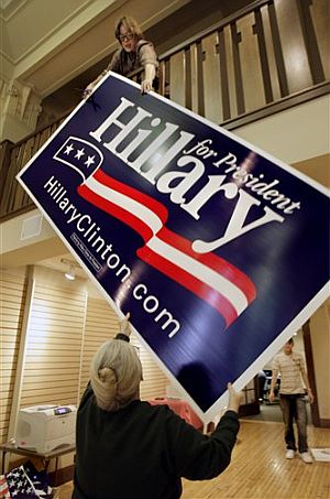 Unas colaboradoras de Clinton descuelgan el cartel de su carrera en su cuartel central de Washington: (Foto: AP)