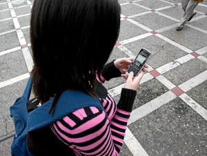Una joven manda un sms con su mvil. (Foto: Pablo Requejo)