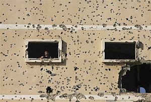 Un palestino, asomado a la ventana de un edifico completamente daado por los tiroteos. (Foto: AP)