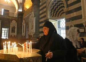 Una mujer siria enciende una vela en la iglesia de Mariamiyah de Damasco. (Foto: Louai Beshara )
