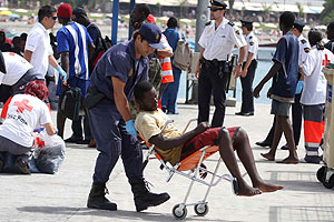 n agente de la polica traslada a uno de los 179 inmigrantes llegados a Canarias. (Foto: Manuel Lrida | EFE)