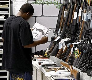 Un hombre hojea un catálogo en una tienda de venta de armas. (Foto: EFE)
