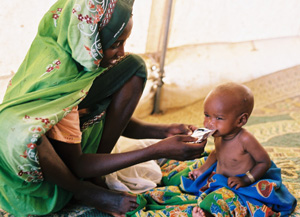 Una madre etope da el alimento teraputico a su hijo. (Foto: MSF)