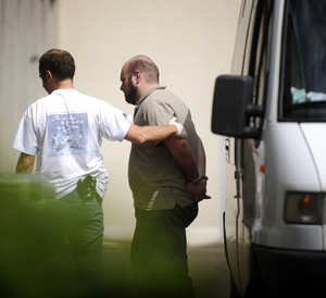 Asier Eceiza, custodiado por un polica tras su detencin. (Foto: AFP)