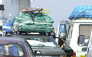 Vehculos cargados con abundante equipaje en espera de embarcar rumbo al continente africano.
