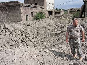 Un georgiano mira el agujero que ha dejado una bomba lanzada desde un avin en la ciudad de Gori. (Foto: EFE)