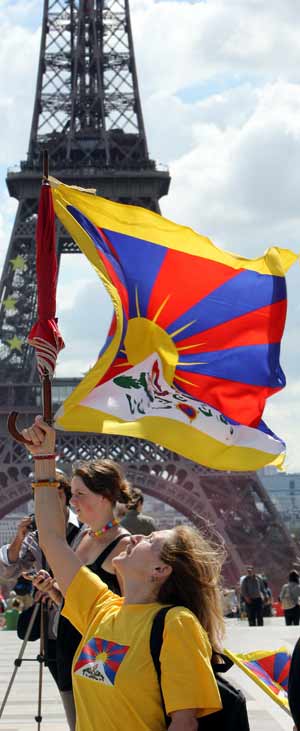Una manifestante sostiene la bandera tibetana frente a la Torre Eiffel. (Foto: AFP/Patrick Kovarik)