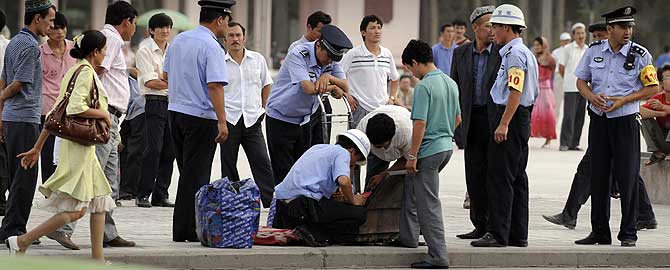 Policas chinos inspeccionan los equipajes de uigures en Kashgar. (Foto: AFP/Peter Parks)