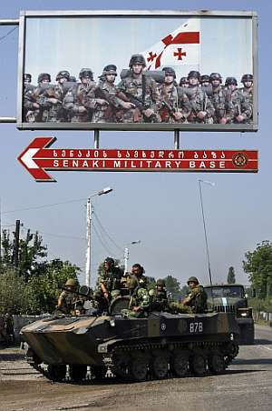 Un transporte APC ruso pasa bajo un cartel del Ejrcito georgiano en Senaki. (Foto: AFP)
