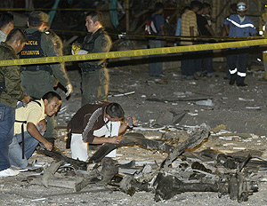 Policas colombianos inspeccionan los restos del coche bomba en Cali. (Foto: Reuters)