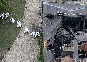 Un grupo de forenses trabaja en la mansión destruida. (Foto: EFE)