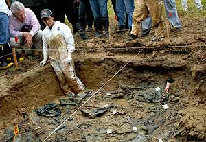 Garzn habla con una forense durante la exhumacin de ms de 20 vctimas de los escuadrones paramilitares en Colombia. (Foto: EFE)