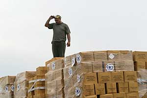 Un hombre sobre un montn de cajas de ayuda humanitaria procedente de Espaa para las vctimas del huracn 'Ike'. (Foto: REUTERS)