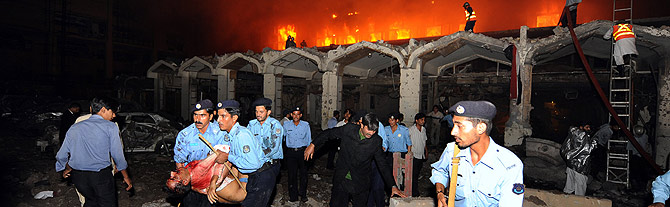 Varios policas rescatan un cuerpo mientras arde el hotel. (AFP)
