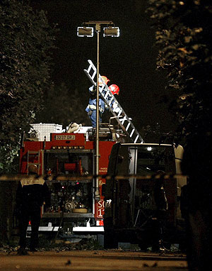 Unos bomberos despliegan una escalera en el lugar. (Foto: EFE)