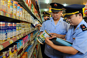 La polica controla la leche en polvo Sanlu en un supermercado de Zaozhuang. (Foto: China Daily | Reuters)