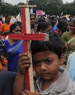Un niño sostiene una cruz de madera durante una concentración cristiana en Karnataka. (Foto: EFE)