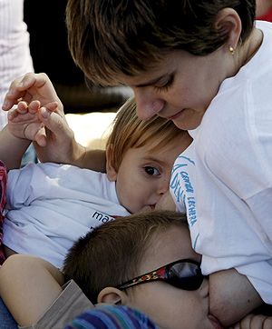 Una mujer da el pecho a sus dos hijos en Viveros (Foto: EFE).