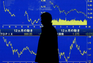 Un asalariado pasa frente a la pantalla que muestra la curva negativa de la bolsa de Tokio en los últimos 12 meses. (Foto: EFE)