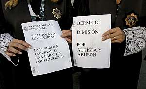 Dos secretarias judiciales muestran carteles de protesta ante las puertas de la Ciudad de la Justicia de Valencia. (Foto: EFE)