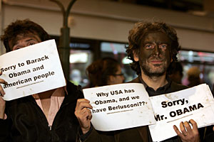 Dos italianos protestan por los comentarios de Berlusconi con carteles que piden perdn a Obama. (AP)