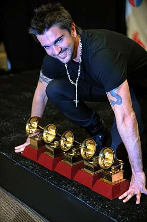 Juanes muestra a la cmara los galardones obtenidos. (Foto: AFP)