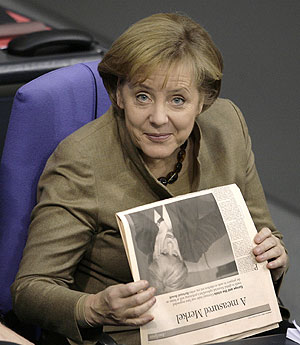 Merkel sujeta un ejemplar de 'Financial Times' en su escao. (Foto: AP)